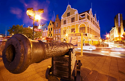  > Evening shot of a cannon with Dutch architecture in Punda, Willemstad, Curacao, Netherlands Antillies